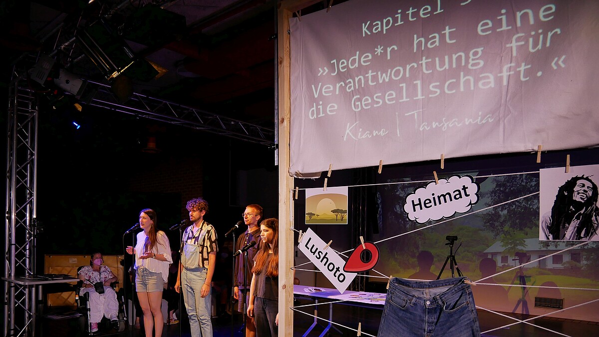 Studierende performen ein Theaterstück auf der Bühne